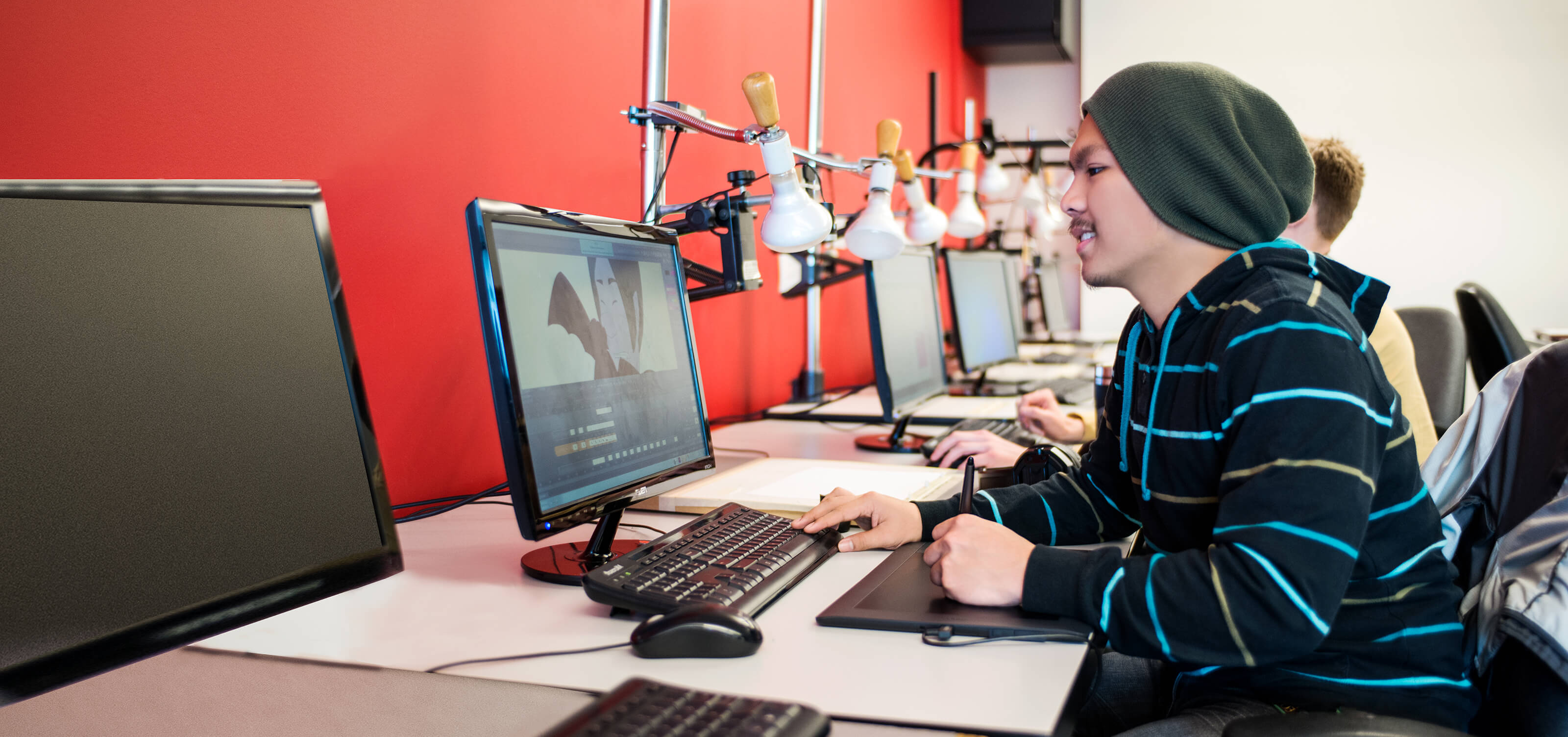 A DigiPen student smiling as he works on a computer animation