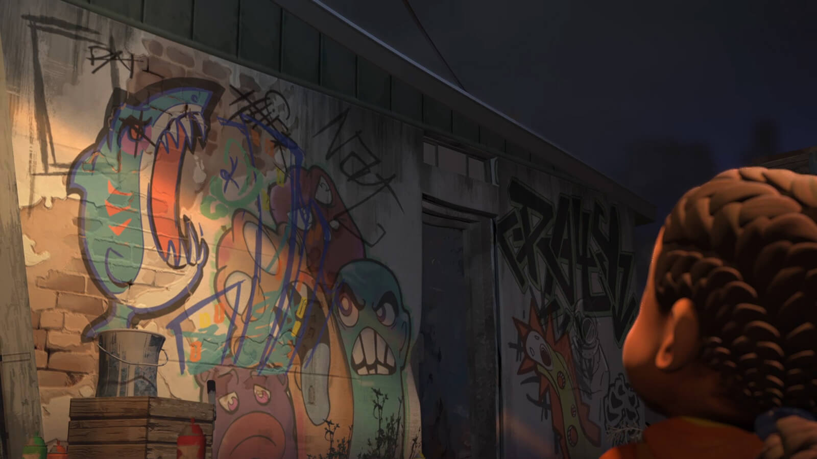 A young girl from behind looking at a dimly lit exterior wall covered in colorful graffiti