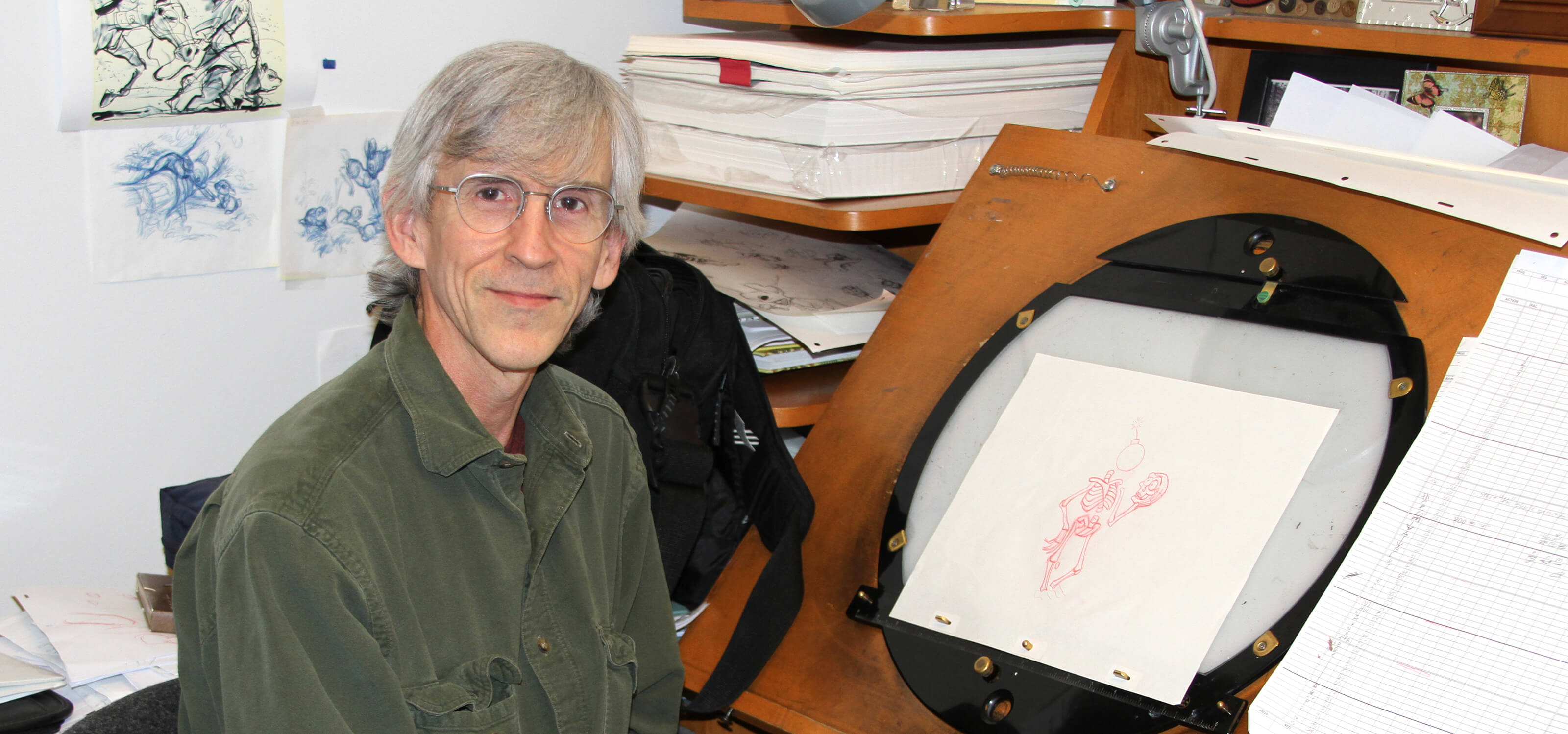 DigiPen animation professor Dan Daly sits at his desk with an original rough in-between drawing from the Aladdin game.