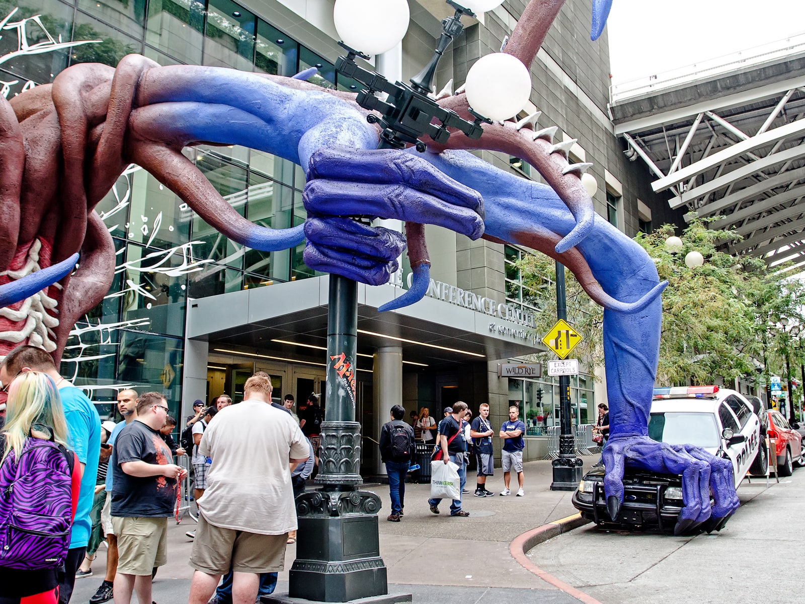 A huge clawed hand crushes a police car outside the Washington State Convention Center for PAX 2015