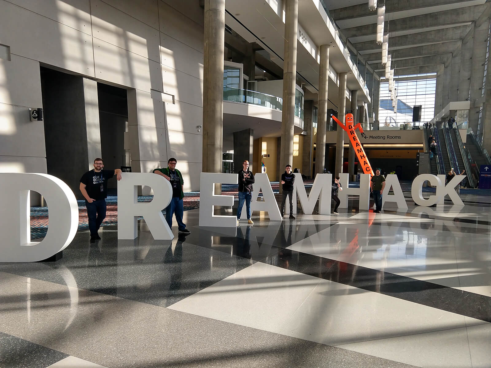 Six DigiPen students stand next to giant letters that spell out ‘DREAMHACK’
