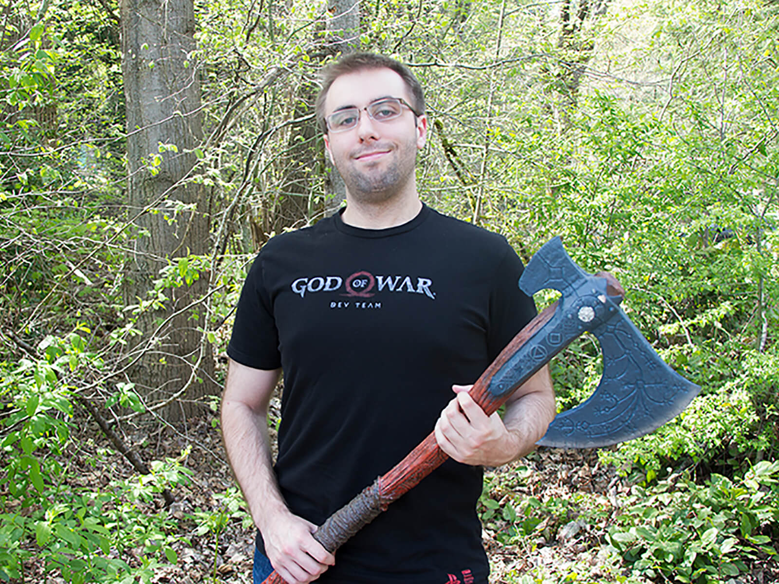 DigiPen alumni Ryan Baker poses with a fake ax on the DigiPen campus