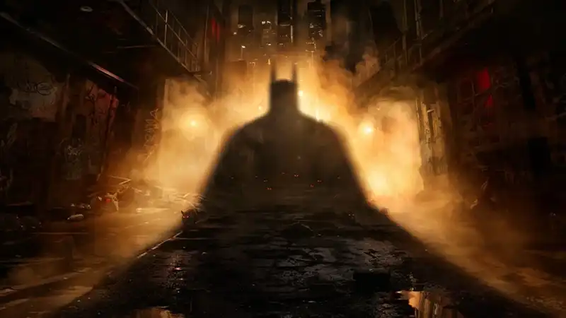 The shadow of Batman looms against the light of an industrial warehouse.