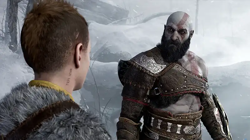 Kratos character from God of War Ragnarok looks sternly at his son, Atreus, in a snowy environment.