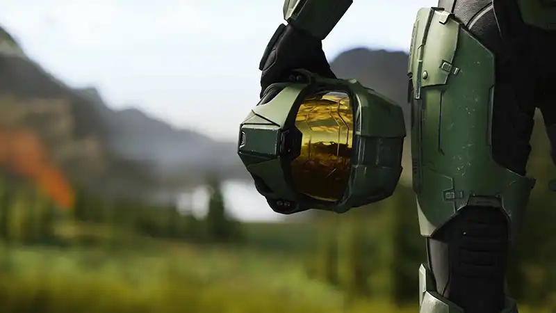 A Halo Infinite screenshot of Master Chief holding his helmet at his waist.