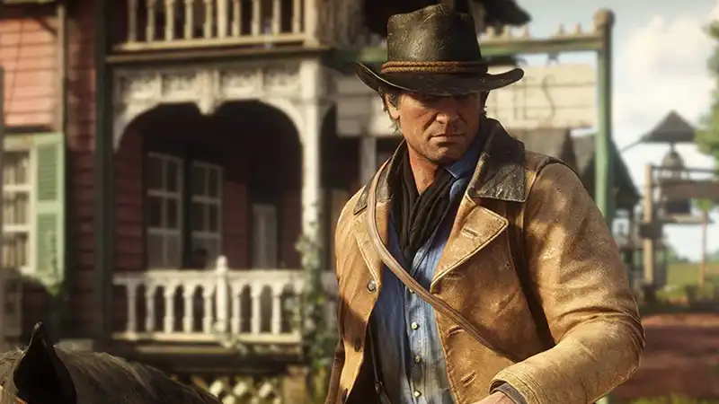 Red Dead Redemption 2’s protagonist Arthur Morgan rides into town on his horse.