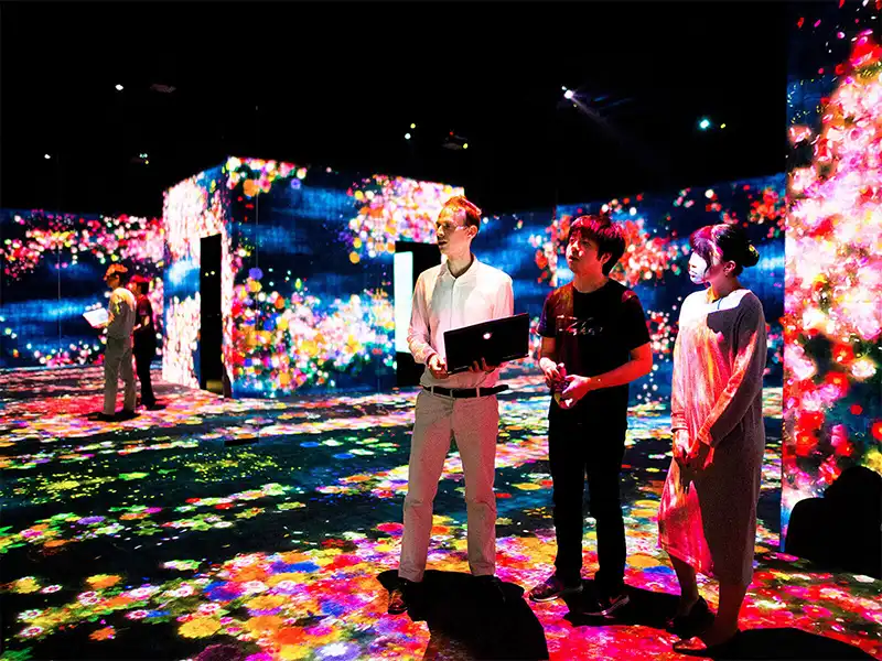 Elliott Davis stands with coworkers in teamLab’s Borderless museum.