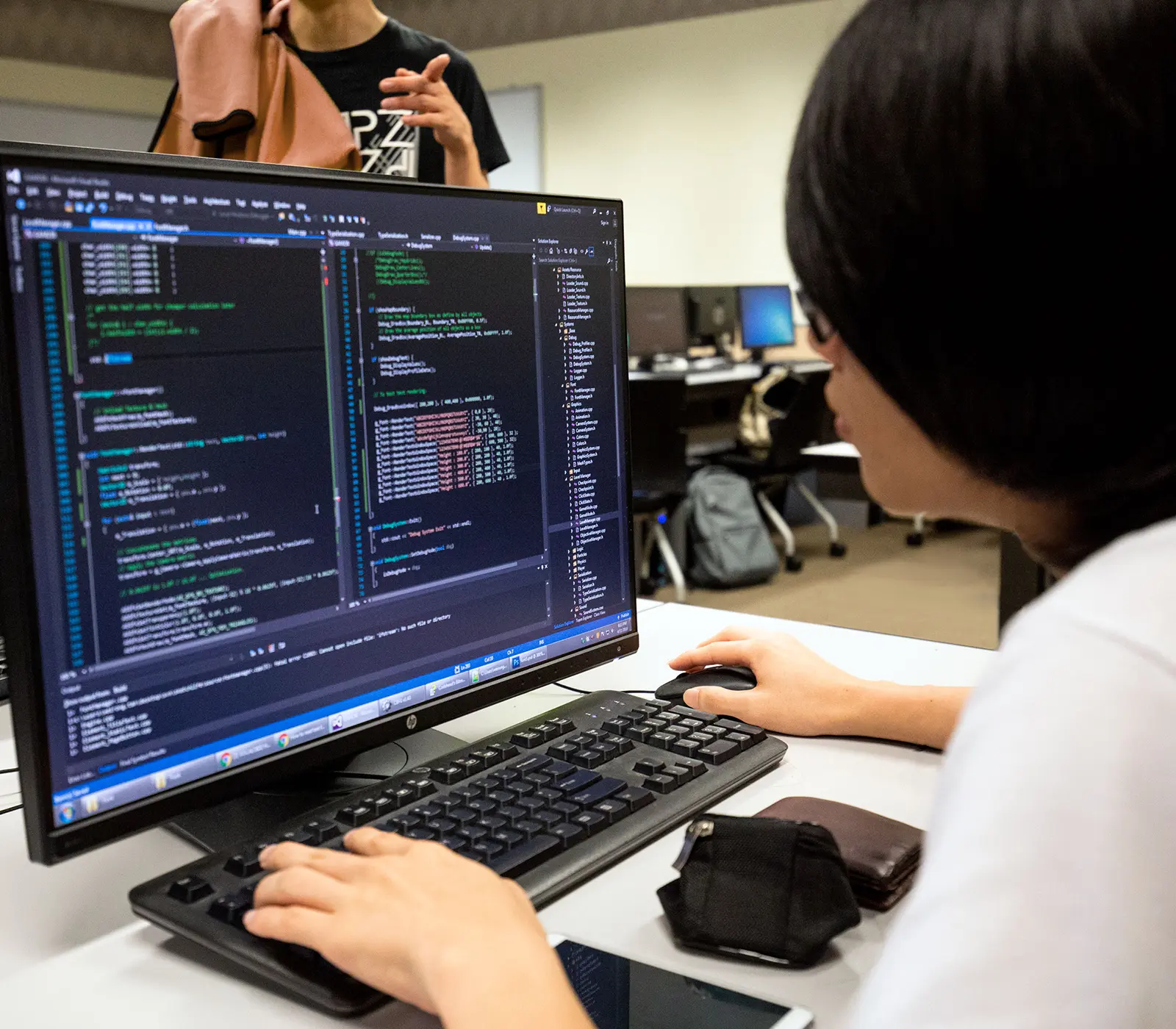 A DigiPen student intently navigates complex code on her computer.