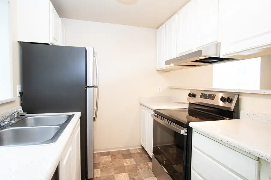 Kitchen with a sink, fridge, and appliances.