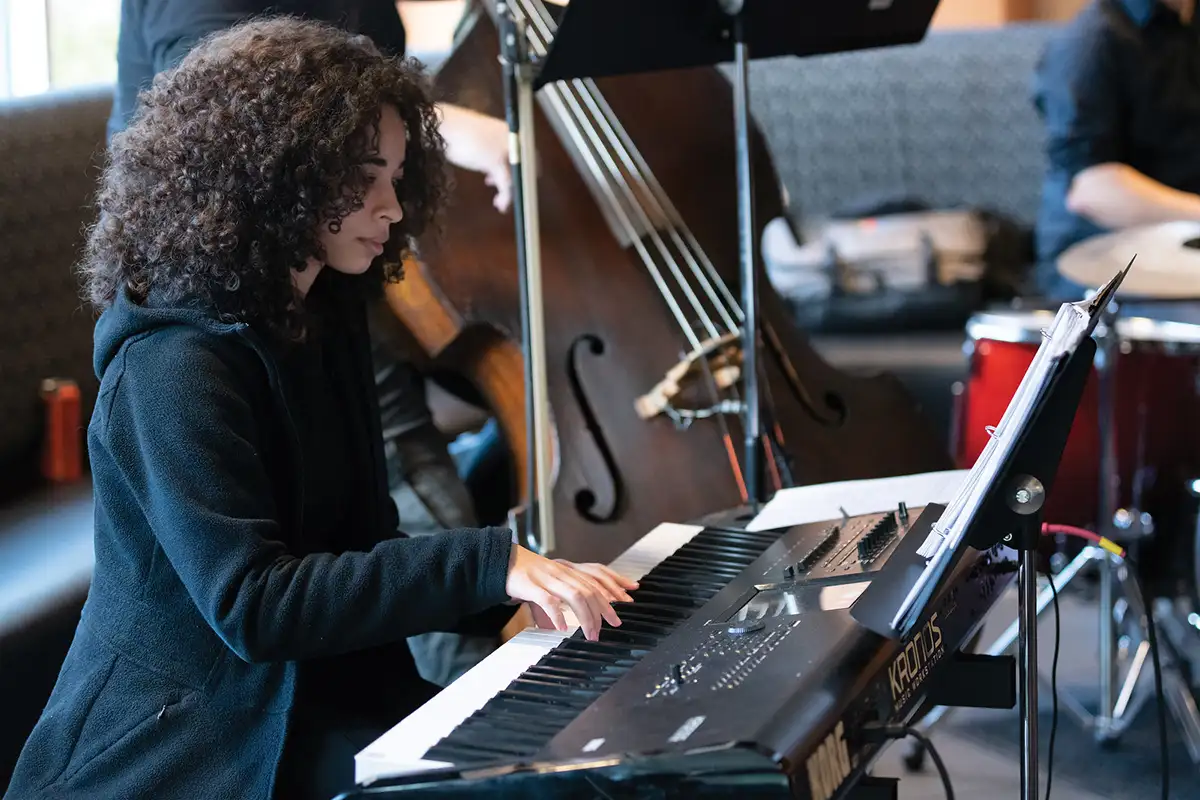 A DigiPen student concentrates at a piano.