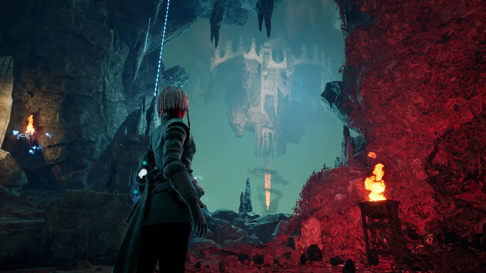 A woman in a deep mystical cavern gazing out of a cave mouth at ancient architecture.