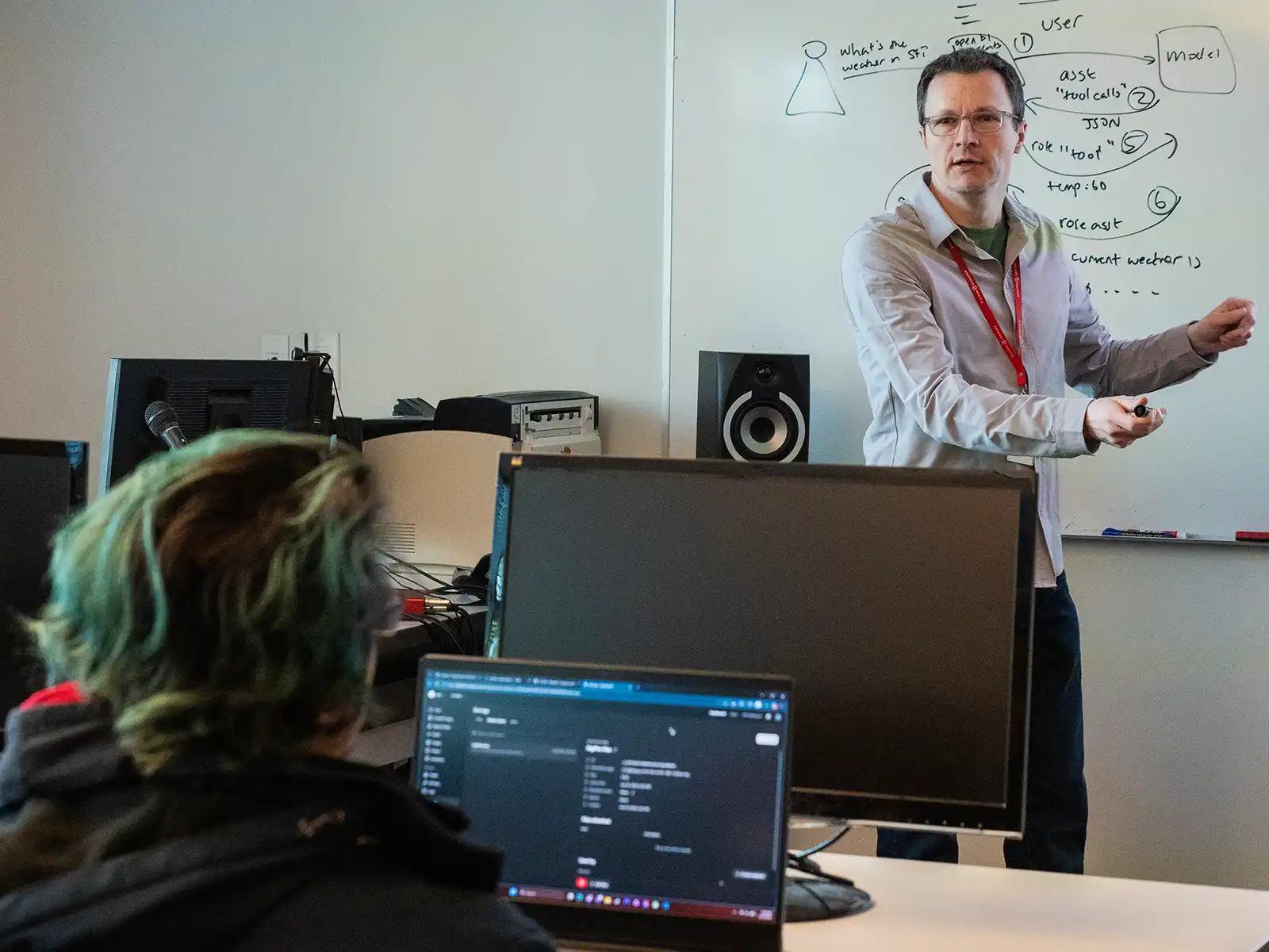 Simon Guest teaches in front of a class.