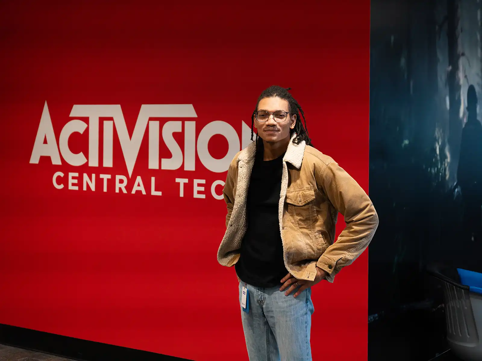 Alum stands in front of red wall with Activision logo.
