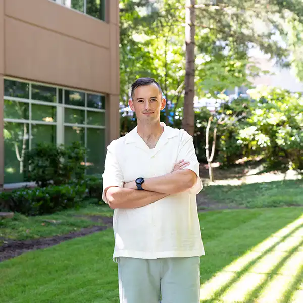 Alex Williams stands on the lawn outside the DigiPen campus building.