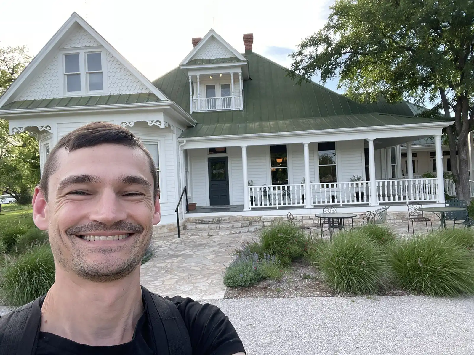 Nate Purkeypile takes a selfie in front of a white house.