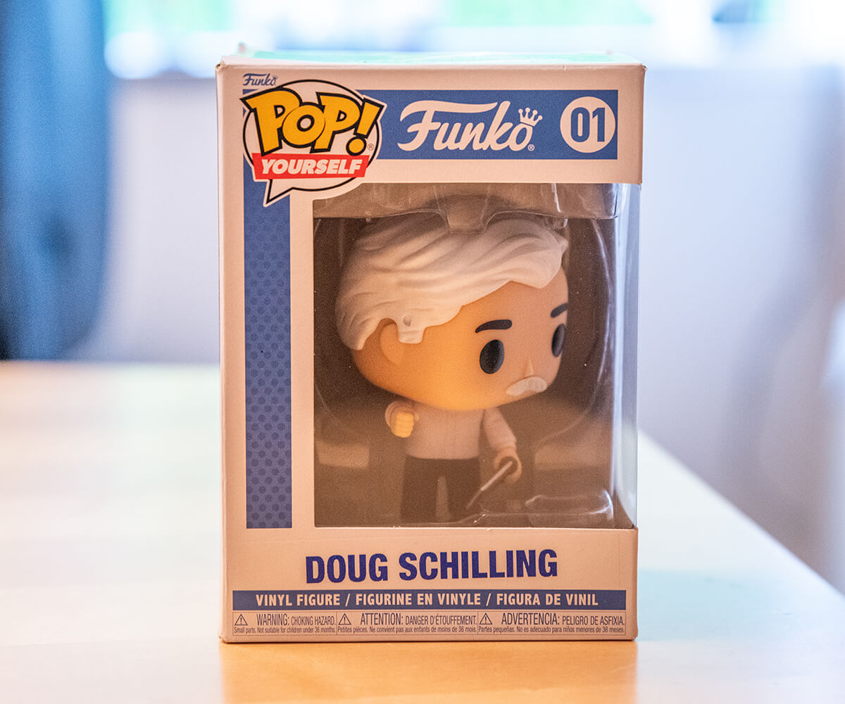 A Funko Pop bearing the likeness of DigiPen professor Douglas Schilling, in its original packaging.