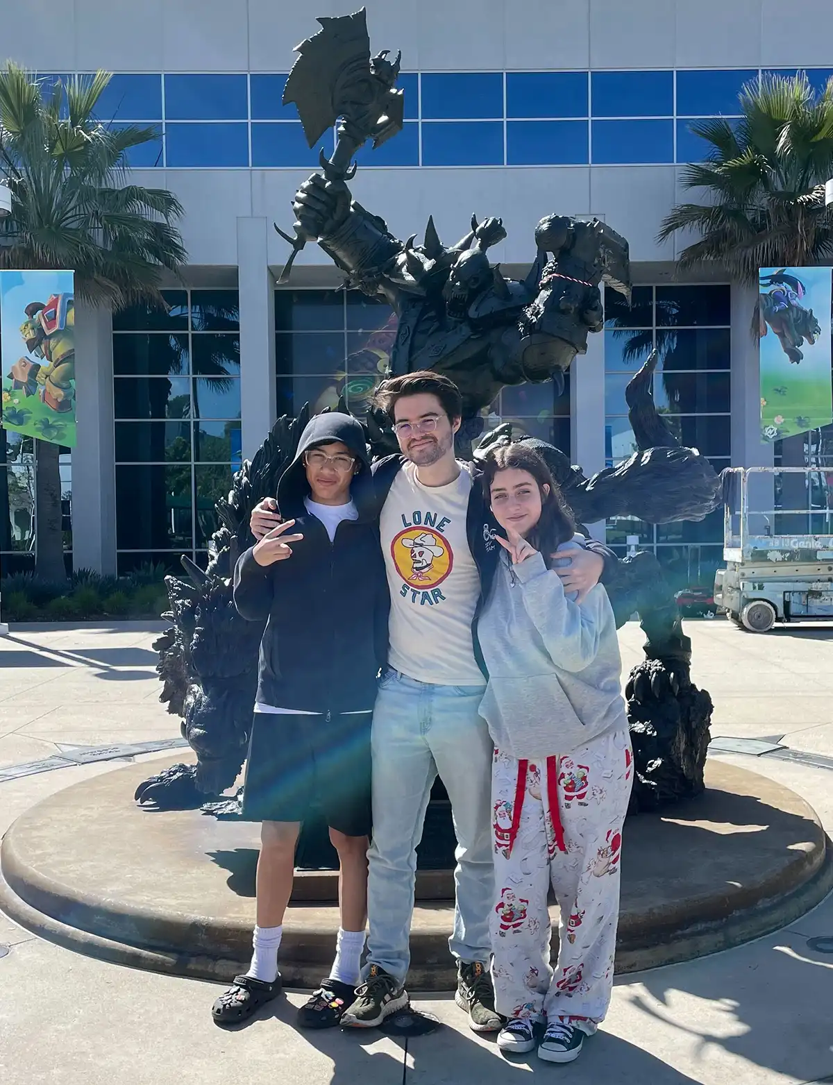 Rivas poses with his brother and sister in front of an orc statue at Blizzards California offices.