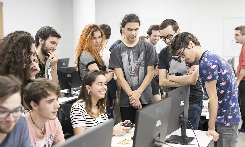 Students congregate by a computer.