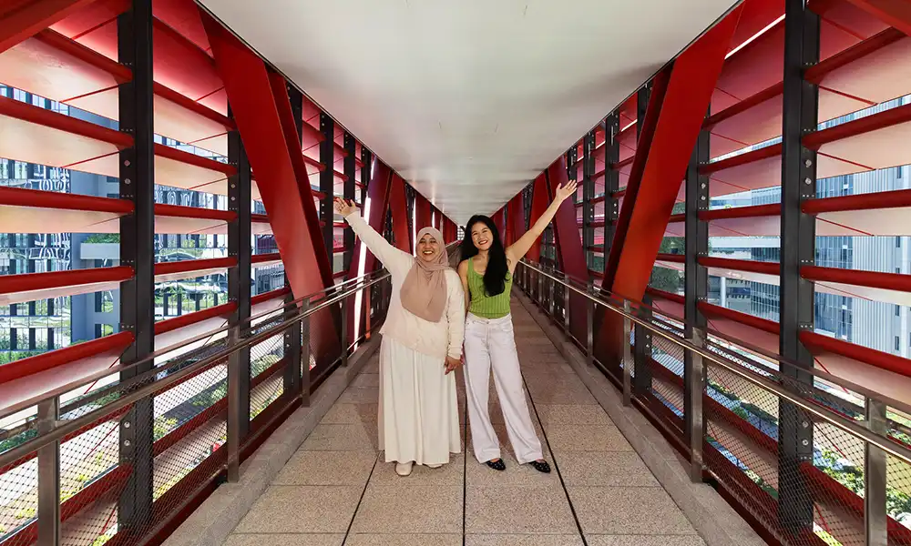 Two students pose in a stylish hallway