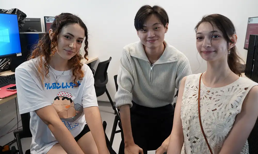 Three students pose for a photo.